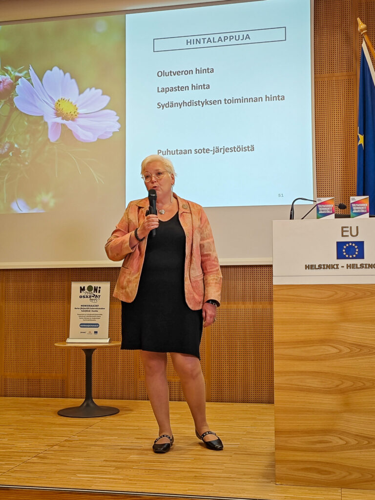 Saana Sandholm puhumassa Moniosaajat-hankkeen päätöstilaisuudessa 30.10.2025